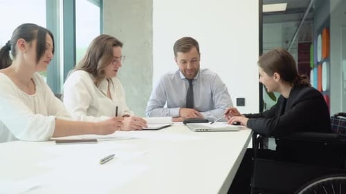 Diverse Group of Work Colleagues Talking at Office Meeting One in Wheelchair