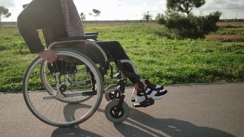 Adult Using Wheelchair on Paved Path