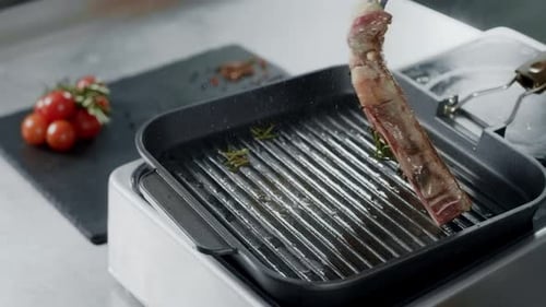 Steak Cooking on Grill With Tomatoes and Rosemary