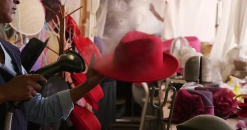 Mixed race woman working at a hat factory