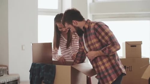 Young Couple Unpacking Boxes in Bright Home