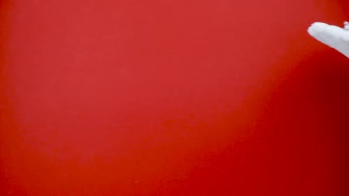 Mão de Papai Noel segurando um pequeno carro de brinquedo vermelho