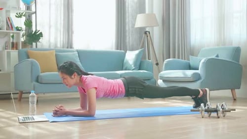 Young Woman Doing Plank Exercise at Home
