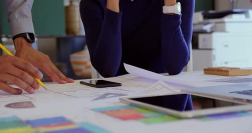 Business people discussing over blueprint in a modern office 4k