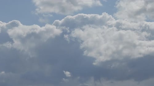 Wolken bewegen sich gegen den blauen Himmel