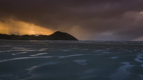 Regnerische Wolken bei Sonnenuntergang über dem Strand