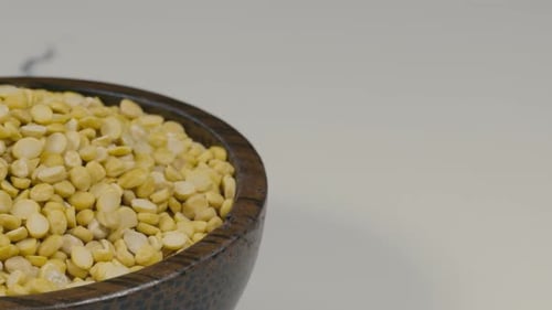 Yellow Split Peas in Rustic Wooden Bowl