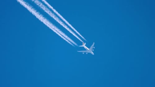 Jet Plane Leaves a White Trail in the Blue Sky