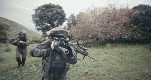 Squad of fully armed commando soldiers during combat in a forest scenery