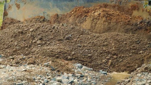 Close Up of Land Leveling a Bulldozer. Stones and Clay Fill the Empty Pits of the Mountain Road with