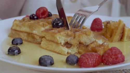 Waffle with Berries Being Cut on a Plate