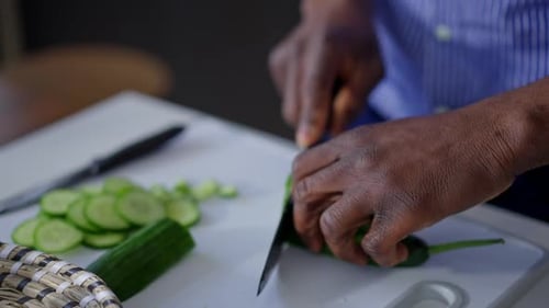 Adult slicing cucumber on cutting board