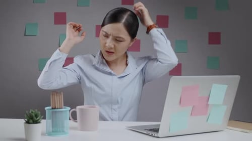 Confused Woman at Desk Scratches Head