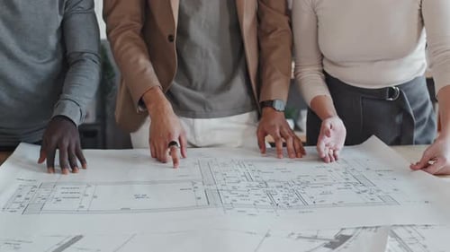 Three People Reviewing Architectural Plans