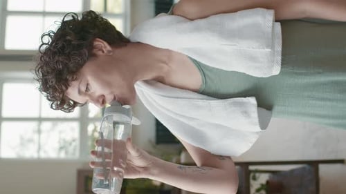 Vertical Portrait of Woman Drinking Water after Workout
