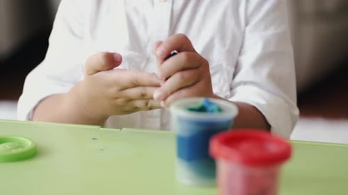 Cropped View of Children Making Figurines From Plasticine at Home