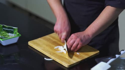 The cook cuts the onion