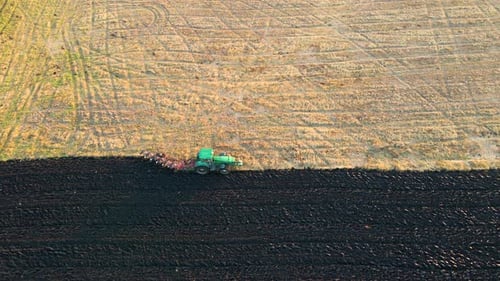 Aerial View of a Tractor Plowing Agricultural Farm Field