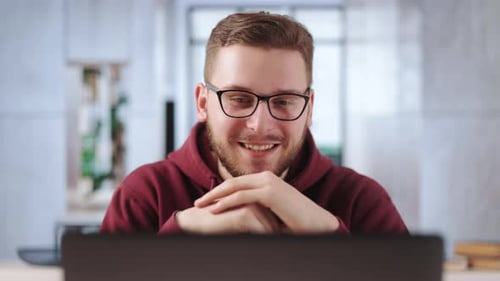 Young Man Chatting on Laptop in Home