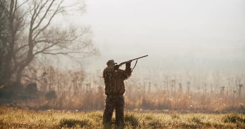 Jäger in Jagdausrüstung Zielen Sie mit einem Gewehr auf das Ziel