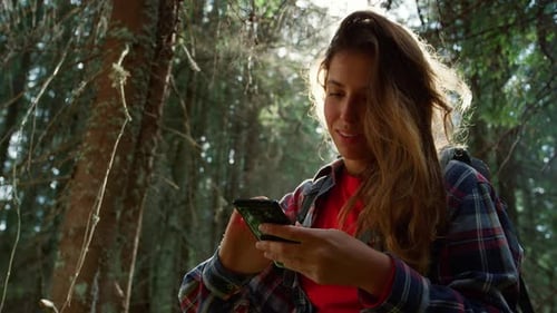 Woman Using Smartphone in Summer Forest