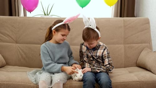 Girl and Boy with Bunny on Sofa
