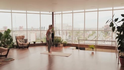 Young Woman Practicing Yoga in Bright City Studio