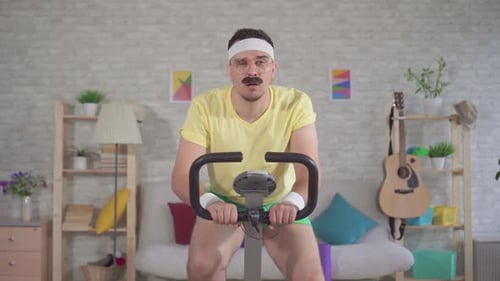 Man on Exercise Bike in Living Room