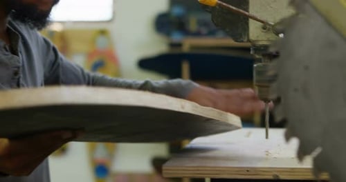 Man Drilling Wooden Board with Drill Press