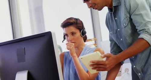 Führungskräfte interagieren bei der Arbeit an Computer und digitalem Tablet 4k