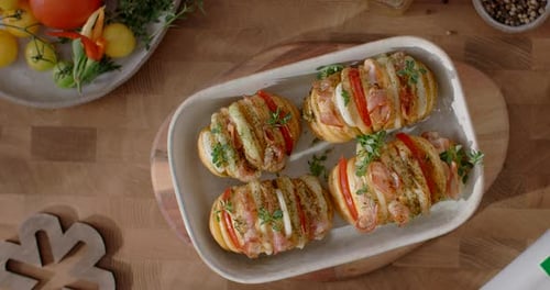 Vidéo de table montrant un plat de pommes de terre et de viande parsemé de légumes verts crus et d'herbes au ralenti