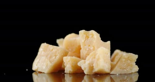 Des morceaux de parmesan sur la table en rotation lente.