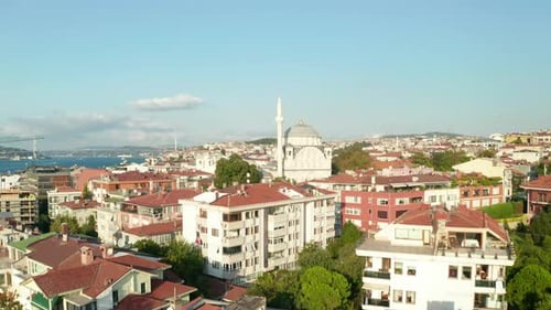 Passing a Mosque in Istanbul Neighbourhood with Bosphorus and Bridges in Background, Aerial