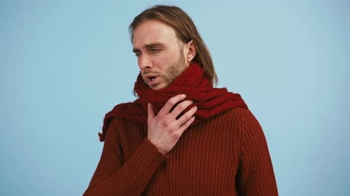 Man Has a Sore Throat and Coughing Looking Unhappy and Ill While Posing Against Blue Studio