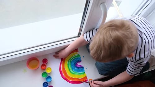 Child Painting a Colorful Rainbow by Window