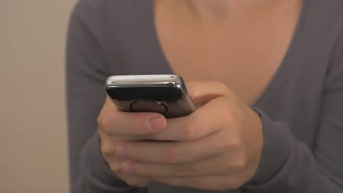 Woman Holding Cellphone Device Indoors