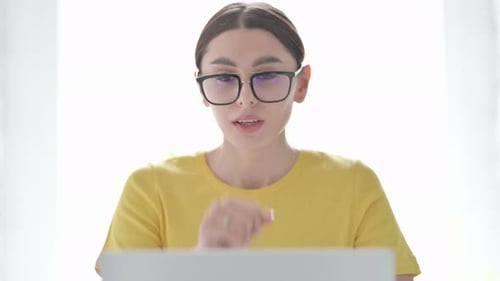 Young Adult Woman Coughing in Front of Laptop