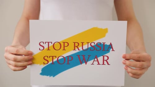 Hands is Holding a Poster with the Image of the Ukrainian Flag Which Says Stop War Stop Russia