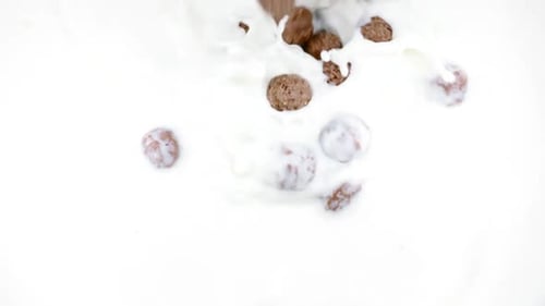 Chocolate Cereal Being Poured Into a Bowl of Milk