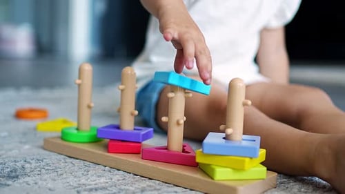 Cute Caucasian Little Girl Playing on the Floor at Home with Eco Wooden Toys