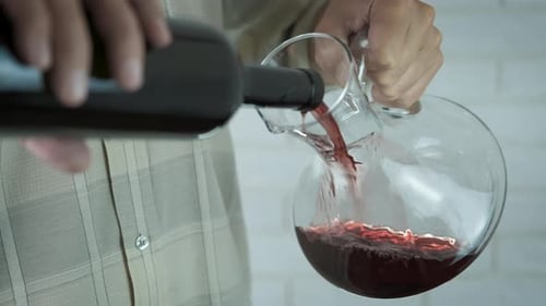 Le vin est versé dans une carafe.