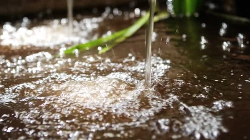 Wasser fließt vom Wasserhahn in den Pool