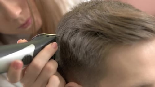 Woman Giving Young Adult a Haircut