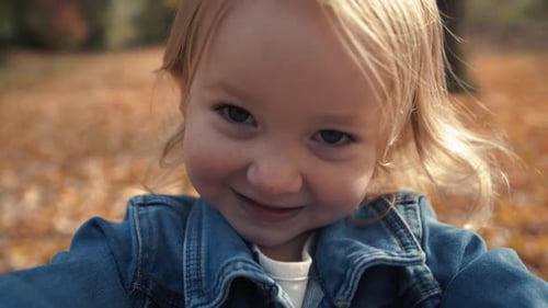 Extreme Close Up Of Happy Little Blond Girl In Fall Season