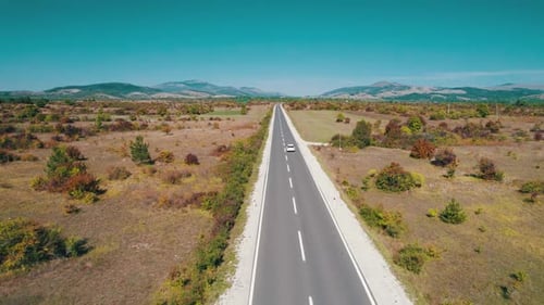 Empty Asphalt Road on the Plateau Between Green Fields Highland Way Aerial View