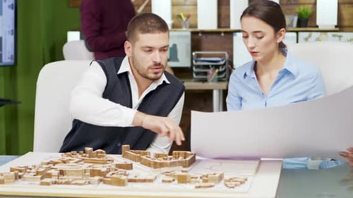 Team of Architect Holding Blue Print and Working with Building Models