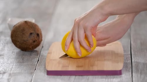 Slicing a Mango on a Wooden Board