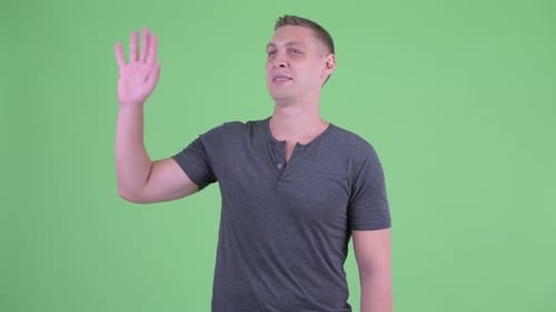 Portrait of Happy Young Man Waving Hand