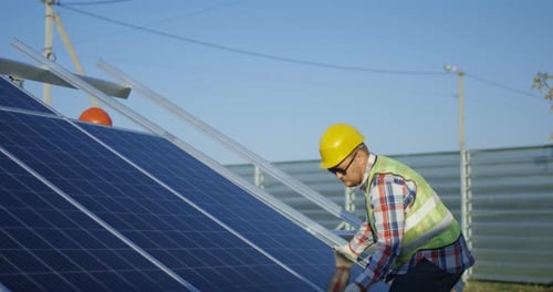 Zwei Arbeiter installieren ein Solarpanel
