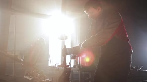 Man Forging Metal in Workshop